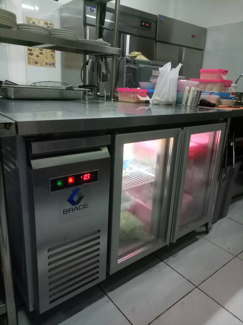 Under counter chiller adalah mesin pendingin berbahan stainless steel yang dirancang khusus untuk ditempatkan di bawah meja kerja (countertop) dapur komersial, seperti di restoran, kafe, atau hotel. Alat ini berfungsi ganda: menyimpan bahan makanan/minuman agar tetap segar (suhu \(2-8^{\circ }\text{C}\)) sekaligus menyediakan ruang kerja tambahan di atasnya. 